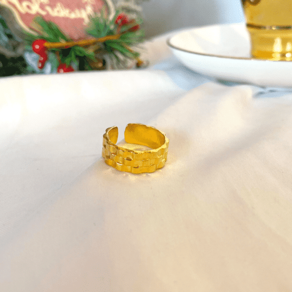 anillo dorado con textura de tejido, ropa gallardo, ecuador